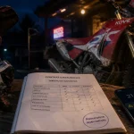 Assurance moto Kove : casque et contrat en atelier, moto trail au fond
